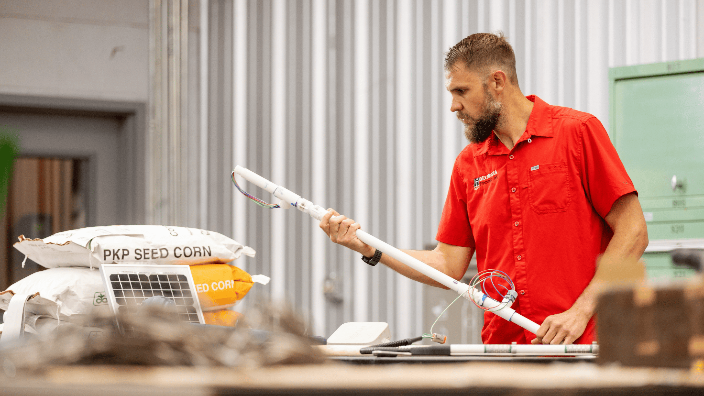 Man with research equipment and bags of seed corn